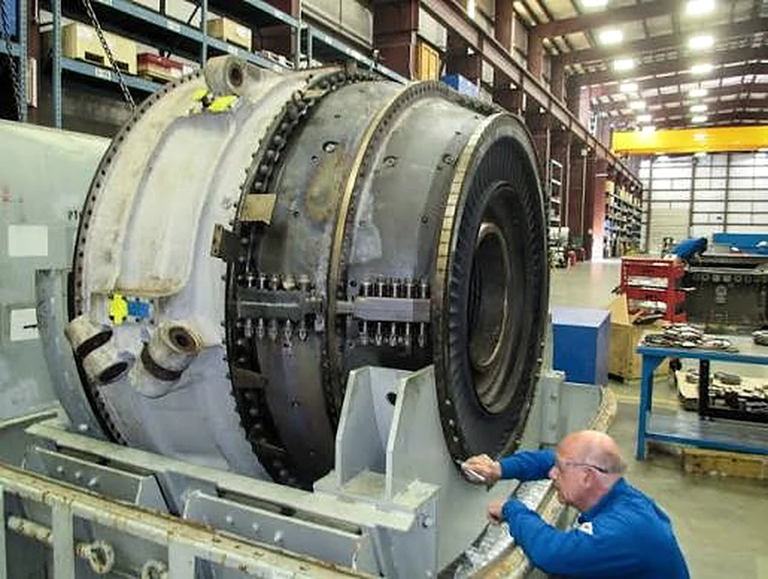 Engineer inspecting an opened gas turbine casing and blading on the shop floor
